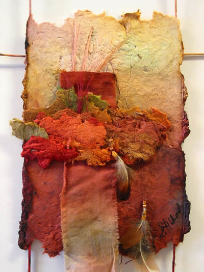 handmade paper wall piece in shades of white, rust and misc. Feathers. 12x16