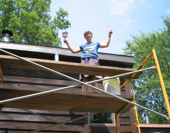 Photo of Pat Littlefield on scaffolding painting house